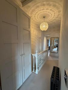 einen Flur mit Tür und Kronleuchter in der Unterkunft West Bridgford 2 Bed 2 Bathroom Apartment with parking in Nottingham