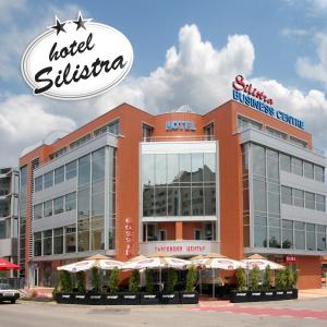 a hotel sitzka building with umbrellas in front of it at Family Hotel Silistra in Silistra
