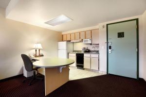 a small kitchen with a table and a table and chairs at Allure Suites of Fort Myers in Fort Myers