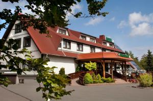 ein großes weißes Gebäude mit rotem Dach in der Unterkunft Waldhotel Rennsteighof in Bad Liebenstein