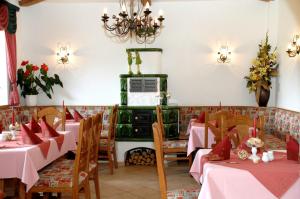 un ristorante con tavoli rosa e stufa verde di Waldhotel Rennsteighof a Bad Liebenstein
