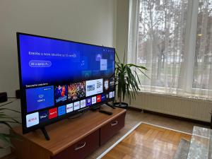 a flat screen tv sitting on a wooden stand in a living room at Su Apartment in Skopje