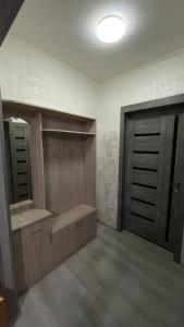 a bathroom with two wooden doors and a mirror at Three Star in Almaty