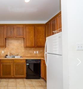 une cuisine avec des armoires en bois et un réfrigérateur blanc dans l'établissement Downtown Room For Active Guests, à Houston