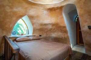 a bedroom with a bed in a room with a window at Dome @Jackfruit Jungle Paradise in Solferino 