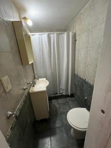 a bathroom with a toilet and a sink and a shower at Las Toninas 46 ll in Las Toninas