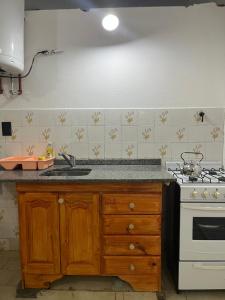 a kitchen with a sink and a stove at Las Toninas 46 ll in Las Toninas