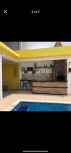 ein Wohnzimmer mit einem Pool und einem Haus in der Unterkunft Casa de praia Enseada in Guarujá