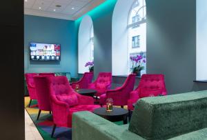 a waiting room with bright red chairs and tables at Thon Hotel Rosenkrantz Bergen in Bergen