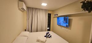 um quarto com uma cama e uma TV na parede em Mare Alta Tamandaré em Tamandaré