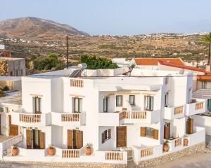 a white apartment building with balconies on a hill at Theoxenia Kasos Luxury Apartments in Panayía