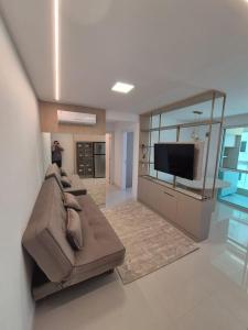 イタペマにあるApartamento NOVO em Itapemaのリビングルーム(ソファ、大きな鏡付)