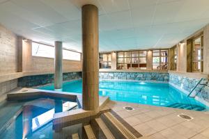 a large swimming pool in a building at Lagrange Vacances Les Fermes Emiguy in Les Gets