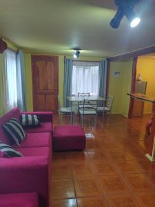 a living room with a purple couch and a table at Cabaña Hornopiren 1 in Hornopiren