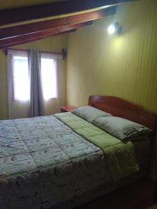 a bedroom with a bed and a window at Cabaña Hornopiren 1 in Hornopiren +9 photos