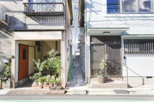 an alley with potted plants on the side of a building at Manere in Tokyo