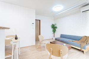 a living room with a blue couch and a table at Manere in Tokyo