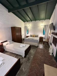 a large room with two beds and a living room at Posada Las Camelias in Estancia La Totoro South
