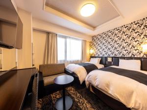 Llit o llits en una habitació de APA Hotel Uozu Ekimae
