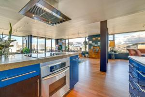 cocina con armarios azules y ventanas de cristal en Luxe Dtwn Reno Penthouse about 3 Mi to Casinos!, en Reno