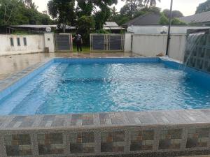 a large blue swimming pool with a man standing in it at ZF Homestay in Kota Bharu