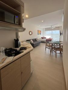 eine Küche und ein Wohnzimmer mit einer Couch und einem Tisch in der Unterkunft Cartagena-Acogedor MorrosEOS Salida directa al mar in Cartagena de Indias