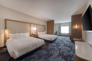 a hotel room with two beds and a flat screen tv at Fairfield Inn & Suites by Marriott Charlotte Belmont in Belmont +29 photos