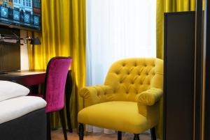 a yellow chair and a table in a room at Thon Hotel Rosenkrantz Bergen in Bergen