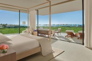 a bedroom with a bed and a patio with a view at The Riviera Maya EDITION at Kanai in Playa del Carmen