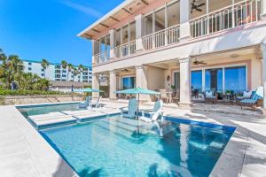 una piscina con sillas y una casa en Ocean Dream Villa, en Clearwater Beach