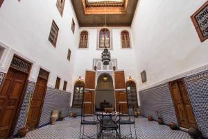 a room with a table and chairs in a building at Dar Nejma in Fez
