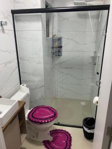 een badkamer met een toilet en een glazen douche bij Apartamento Santa Clara in Balneário Camboriú