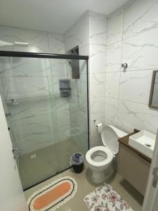 een badkamer met een douche, een toilet en een wastafel bij Apartamento Santa Clara in Balneário Camboriú