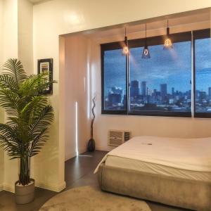 a bedroom with a bed and a potted plant at Voss Condominium in Manila