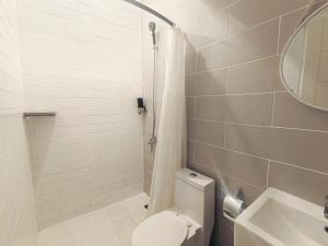 a bathroom with a toilet and a sink and a mirror at Voss Condominium in Manila +41 photos