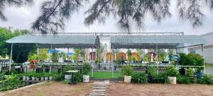 a garden with a pavilion with tables and plants at Ruby Homestay Cần Giờ in Ấp Long An