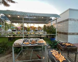 a buffet of food on a table in a garden at Ruby Homestay Cần Giờ in Ấp Long An