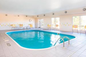 a swimming pool in a hotel room with chairs and tables at Fairfield by Marriott Inn & Suites Cheyenne in Cheyenne