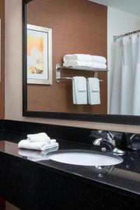 a bathroom with a sink and a mirror and towels at Fairfield Inn & Suites Cheyenne in Cheyenne
