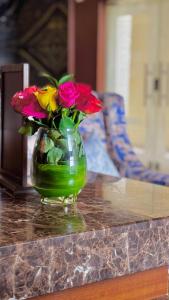 Laten Suites Al Naseem في جدة: مزهرية مليئة بالورود تجلس على منضدة