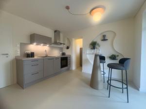 a kitchen with white cabinets and a table and chairs at Villa Haag - Design-Apartment in Fulda +8 photos