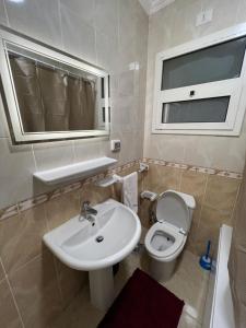 ein Badezimmer mit Waschbecken und Toilette und einem Fenster in der Unterkunft 2 bedroom apartment in rehab cityy in Burg el-Ḥudûd + 8 Fotos