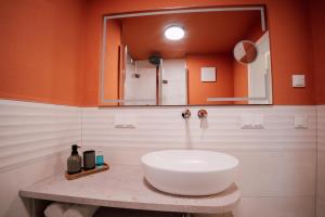 a bathroom with a white sink and a mirror at Villa Haag - Design-Apartment in Fulda