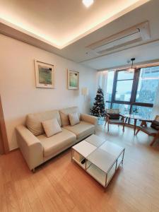 a living room with a couch and a christmas tree at Elbon The beach Haeundae in Busan