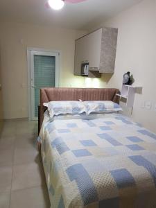 Un dormitorio con una cama con un edredón azul y blanco. en Sossego, en Florianópolis
