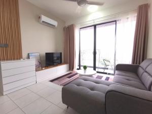 a living room with a couch and a large window at Empire Citystay Astetica 3 Beds in Serdang