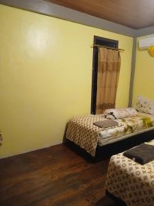 a bedroom with two beds and a window with a laptop at KeyHole Surf Camp in Lagudri