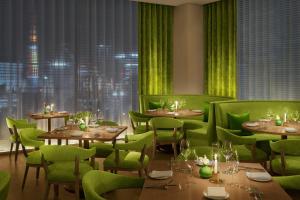 un restaurante con sillas y mesas verdes y una ventana en The Tokyo EDITION, Ginza, en Tokio 32 fotos más
