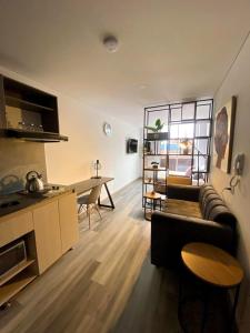 una sala de estar con un sofá y una mesa en Exclusive Aparta - Suite Full Parque de la 93, en Bogotá