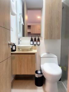 Un baño con un inodoro blanco y un lavabo. en Exclusive Aparta - Suite Full Parque de la 93, en Bogotá